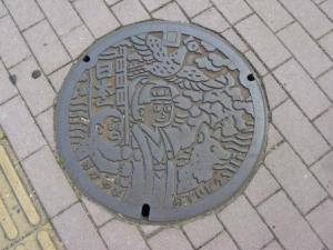 Okayama manhole cover featuring Momotaro, the Peach Boy